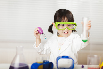 toddler girl pretend play scientist role at home against white background