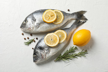 Wall Mural - Fresh Dorado fishes, pepper, lemon and rosemary on white background, top view