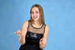 Universal concept horizontal portrait of a woman on a blue background. A photo of a pretty smiling girl with long hair and excellent make-up in a black dress stands in different poses.