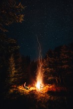 Young Female Sitting On Chair In The Wilderness Forest Near The Big Campfire Under The Milkyway. 