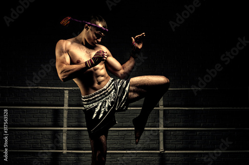 Kickboxer in the ring surrounded by searchlights stretches before the fight Фотошпалери