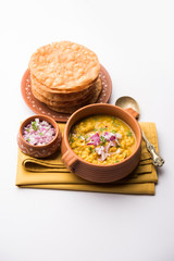 Sticker - Dal pakwan is an authentic Sindhi breakfast. It is a combination of deepfried, crisp and unpuffed Maida puris served with Daal made using chana or split chickpea. selective focus