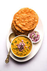 Wall Mural - Dal pakwan is an authentic Sindhi breakfast. It is a combination of deepfried, crisp and unpuffed Maida puris served with Daal made using chana or split chickpea. selective focus