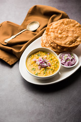 Wall Mural - Dal pakwan is an authentic Sindhi breakfast. It is a combination of deepfried, crisp and unpuffed Maida puris served with Daal made using chana or split chickpea. selective focus