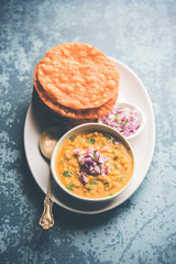 Wall Mural - Dal pakwan is an authentic Sindhi breakfast. It is a combination of deepfried, crisp and unpuffed Maida puris served with Daal made using chana or split chickpea. selective focus