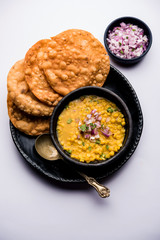 Wall Mural - Dal pakwan is an authentic Sindhi breakfast. It is a combination of deepfried, crisp and unpuffed Maida puris served with Daal made using chana or split chickpea. selective focus