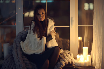 girl sitting in a blanket at the window, candles night, loneliness, young lonely girl, stress