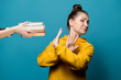 © Вячеслав Думчев - young girl in a yellow sweatshirt on a blue background refuses books