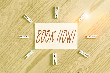 Text sign showing Book Now. Business photo showcasing guaranteed to have place because you have already purchased it Colored clothespin papers empty reminder wooden floor background office