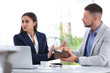 © New Africa - Businesswoman refusing to take bribe at table indoors