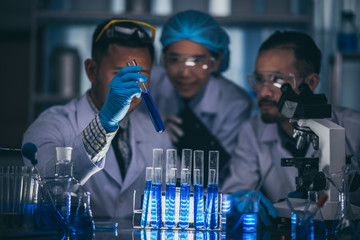 Wall Mural - asian scientist hold a test tube filled with liquid in the laboratory