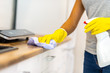 © Andrii - Cropped shot of woman hands wiping surface of countertop, using a rag and detergent.