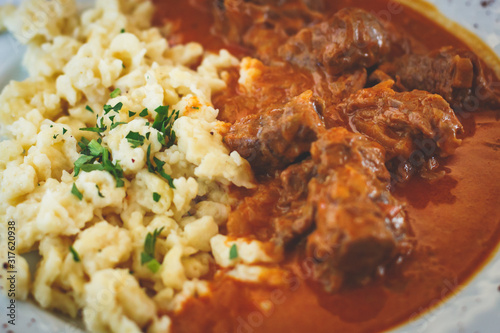 Fotografía Traditional hungarian and austrian dish - beef goulash with garnish egg noodles,