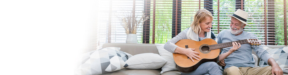 Portrait of happy caucasian senior couple practising guitar. Married mature man woman enjoying playing on music. Love together valentines day of old people. Lifestyle holiday panorama banner