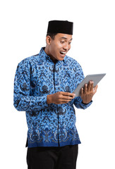 Wall Mural - happiness asian young man wearing batik korpri using tablet digital, government officials of Indonesia