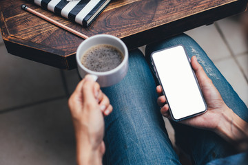 Mockup image blank white screen cell phone.woman hand holding texting using mobile on desk at coffee shop.background empty space for advertise text.people contact marketing business,technology 