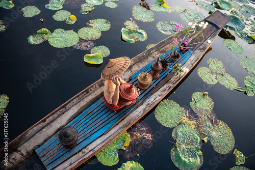 Fotomural Burmese Intha woman in a rowing boat in the morning at In Dain Khone village, on Inle Lake, Myanmar