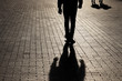 Leinwandbild Motiv Silhouette and shadow of a man walking walking towards a couple on a street. Concept of crime or robbery, relationships, jealousy, social issues