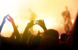 © maxbelchenko - Hand with a phone records live music festival. People taking photographs with smart phone during a public music concert. Crowd raising their hands, dancing and enjoying great the concert.