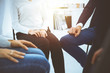 © rogerphoto - Group of people sitting in a circle during therapy in sunny office. Meeting of business team participating in training