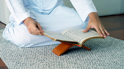 Portrait of an Asian Muslim man woman reciting Surah Al-Fatiha passage of the Qur'an in a single act of Sujud called a Sajdah or prostration in a daily prayer at home