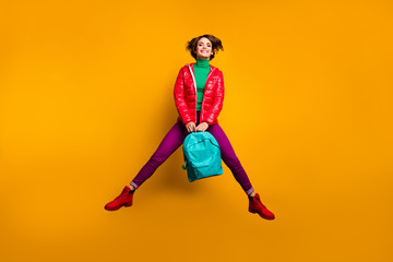 Poster - Full size photo of cheerful funky fun youth scholar girl jump hold blue backpack enjoy emotions wear purple green pants trousers red boots isolated over bright color background