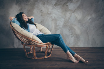 Profile side view portrait of her she nice attractive charming lovely cheerful cheery dreamy wavy-haired girl lying in armchair enjoying at modern loft industrial style interior room