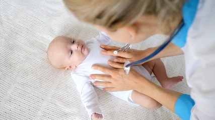 Medicine, Healthcare And Pediatrics Concept - Female Pediatrician Or Neurologist Doctor Or Nurse Checking Baby. Professional Pediatrician Examining Infant.