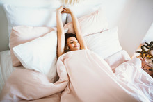 Woman Stretching In Bed After Wake Up