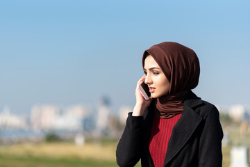 Wall Mural - sad muslim young woman talking by phone	