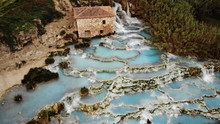 The Famous Ancient Baths Of Saturnia In Tuscany, Which Descend In A Cascade Of Pools From The Therme Waterfall, Blue Hot Springs With Healing Water, An Incredibly Picturesque Outdoor SPA In Italy