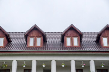 Wall Mural - Several wooden dormers with windows on new brown metal roof.