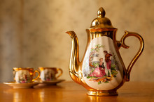Gilded Porcelain Teapot And Two Cups.