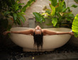 © Nejron Photo - Woman relaxing in outdoor bath with tropical leaves at Bali
