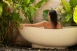 © Nejron Photo - Woman relaxing in outdoor bath with tropical leaves at Bali