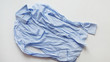 © vladdeep - Blue cotton wrinkled and rumpled shirt on white. Washed shirt after tumble dryer