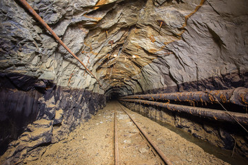 Old gold mine underground tunnel with rails