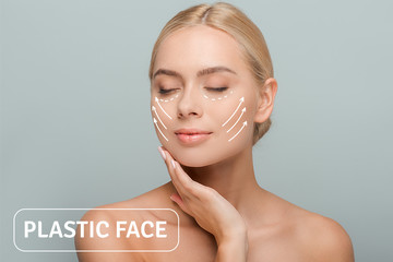 young beautiful woman with closed eyes touching face with plastic surgery marks isolated on grey