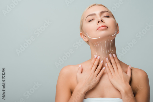 Fotomural beautiful woman touching neck with lifting marks isolated on grey