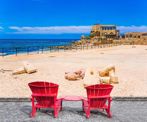 Poster - Two red armchairs stand on embankment