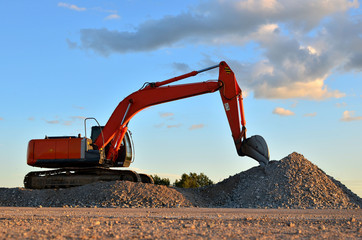 Canvas Print - Excavator loads of stone and rubble for processing into cement or concrete for construction work and reuse. Backhoe at quarry. Develop the glavel stone or aggregate, sand and prismatic blocks