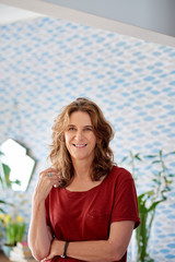 Wall Mural - Mature woman smiling while standing in her stylish apartment