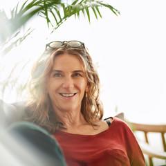 Wall Mural - Smiling mature woman relaxing on her sofa at home