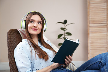 Sticker - Woman listening to audiobook in chair at home