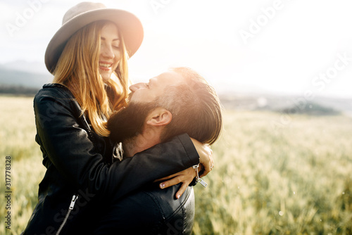 Stylish casual couple on a green field Poster Mural XXL