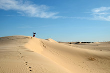Man Jumping Off Sand Dune In Daytime At Monahans Sandhills State Park