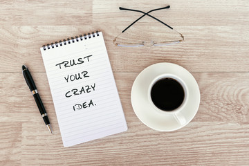 Wall Mural - Inspirational and motivational - Trust your crazy idea text on note pad on top of wood desk