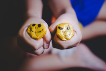 CLOSE-UP OF Child Holding Yellow Scary Faces