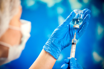 A doctor holding a bottle with vaccine and syringe. Medicine and healthcare concept