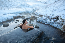 The Girl Bathes In A Hot Spring In The Open Air With A Gorgeous View Of The Snowy Mountains. Incredible Iceland In Winter